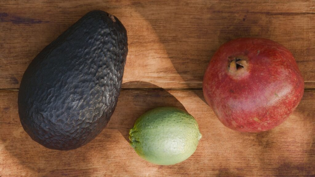 A vibrant mix of the five fruits mentioned avocado blueberries papaya grapefruit and pomegranate arranged beautifully on