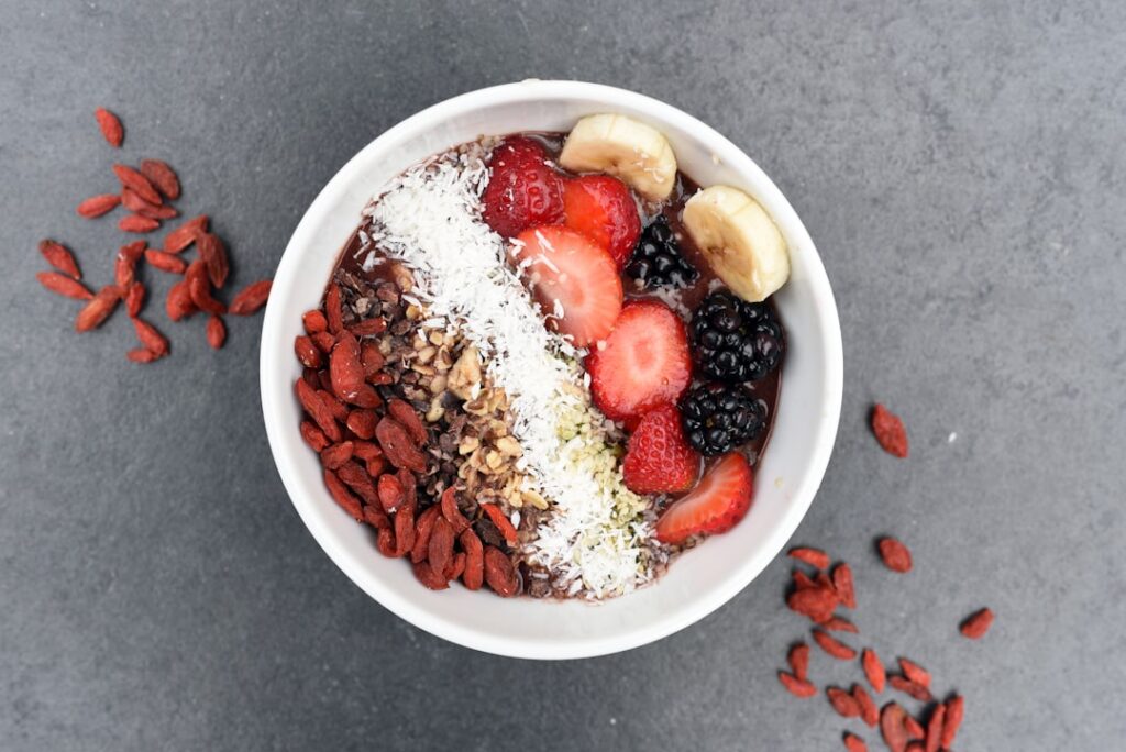 A vibrant well-presented bowl of oatmeal topped with protein powder fresh berries nuts and a drizzle of nut butter on a 