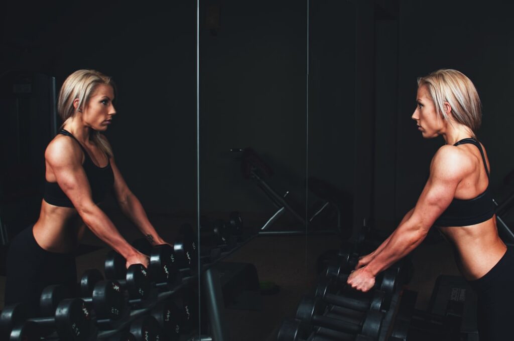 A woman performing a bent-over row with light dumbbells focusing on proper form with a straight back and engaged core