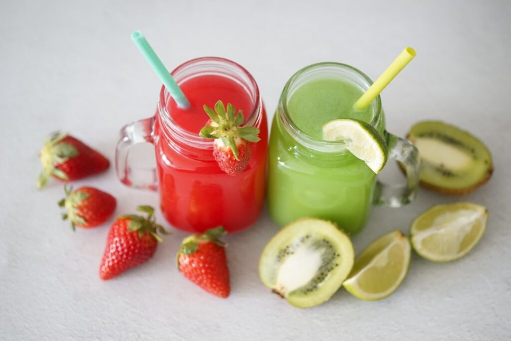 A refreshing glass of a natural fruit collagen drink garnished with fresh berries and mint leaves on a light wooden surf