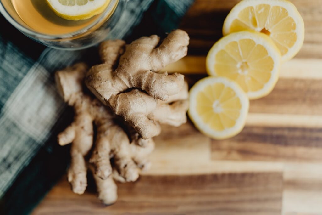 A close-up of fresh ginger root and a whole lemon on a cutting board ready to be prepared for the detox drink