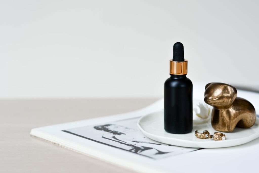 Close-up of dried cloves and a small bottle of clove essential oil with a dropper set on a rustic wooden surface with so