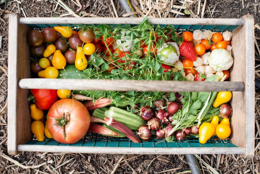 A gardener proudly displaying a basket overflowing with freshly harvested vibrant vegetables and fruits surrounded by he