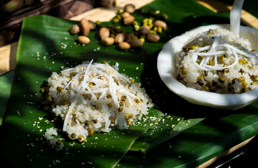 A vibrant green Pandan Sapin-Sapin layered with white coconut-flavored sections topped with grated coconut