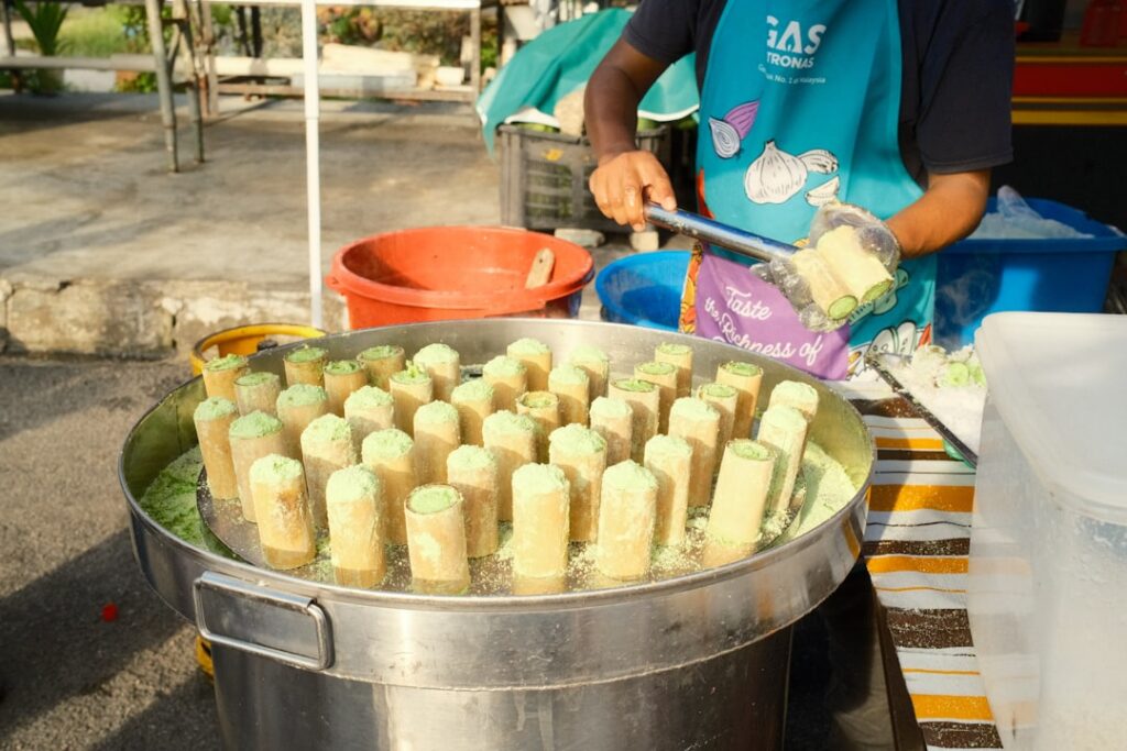Close-up of Buko Pandan Ice Candy in a clear plastic bag with shredded young coconut meat and pandan leaves arranged aro