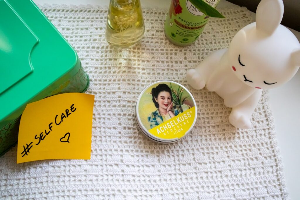 Small jar of homemade Vaseline and Vitamin E balm on a wooden surface with a Vitamin E capsule next to it