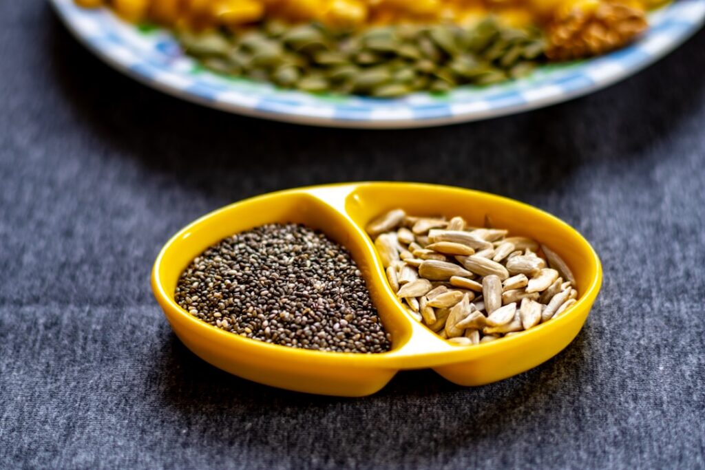 Individual small bowls containing chia seeds flaxseeds and pumpkin seeds ready to be combined