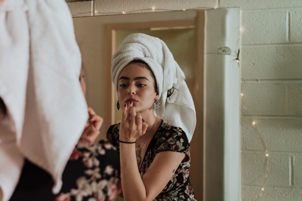 A woman gently applying a small amount of the DIY face balm to her cheek during her nightly skincare routine with soft a