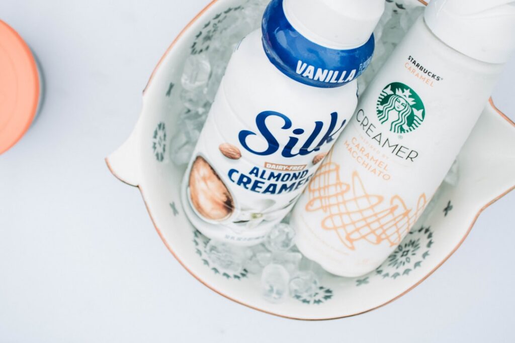 Ingredients for DIY eye cream a small bowl with finely ground coffee a jar of Vaseline and a spoon set on a clean light 