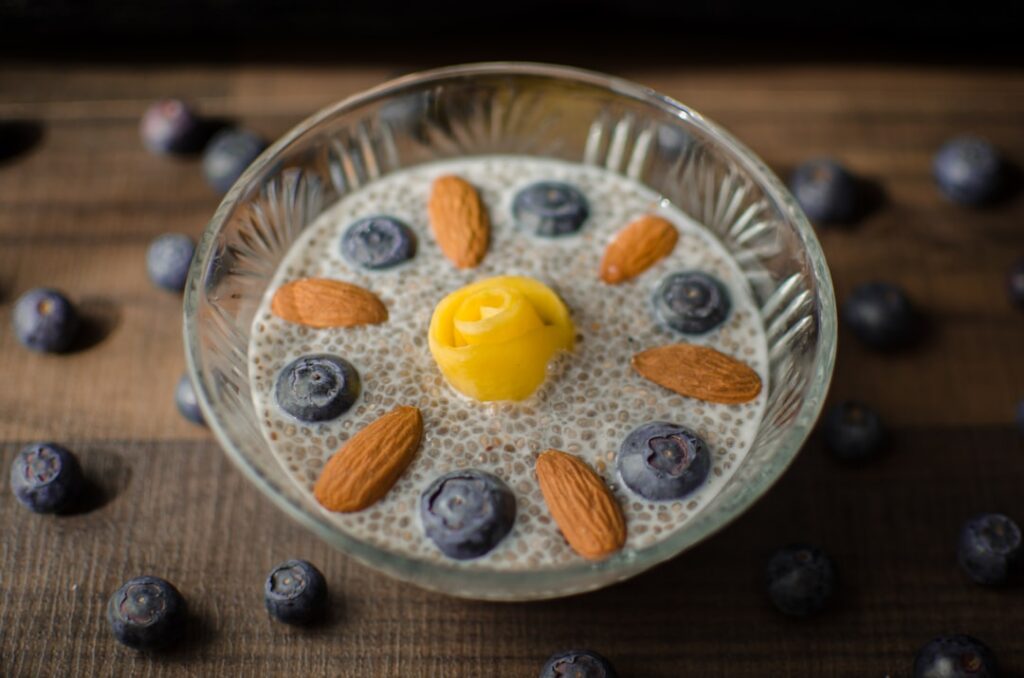 A glass of homemade almond and chia seed collagen tonic garnished with a few whole almonds or a sprig of mint on a light