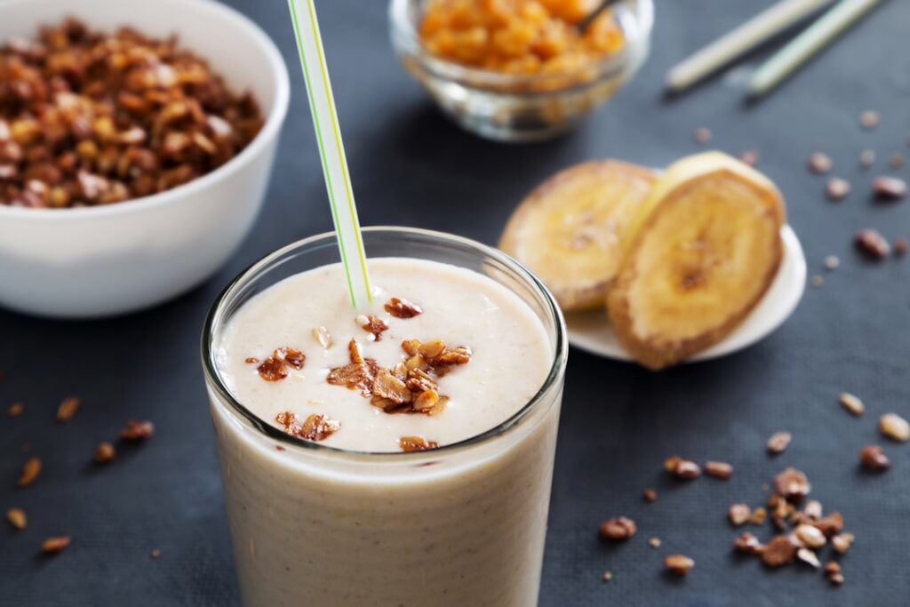 A vibrant fresh smoothie made with yogurt banana and ginger garnished with a slice of banana and a sprinkle of ginger Th