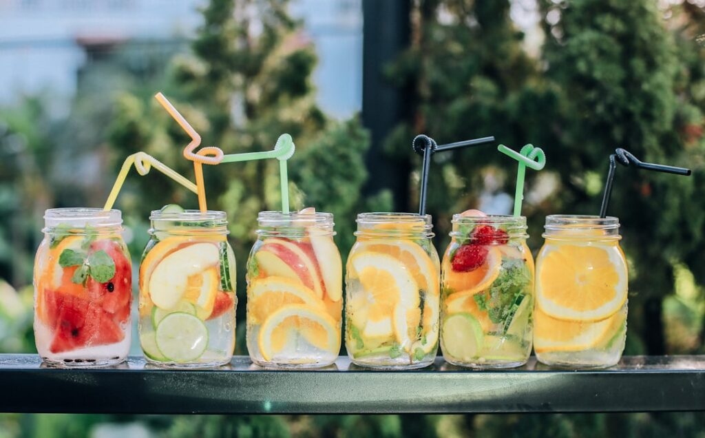 A vibrant assortment of healthy drinks including a green smoothie berry juice and lemon-infused water on a rustic wooden