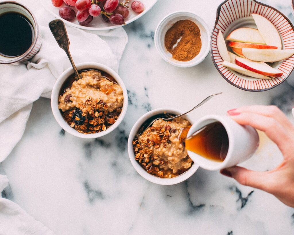 A cozy morning scene with a steaming cup of coffee and a bowl of oatmeal topped with fresh berries and nuts placed on a 