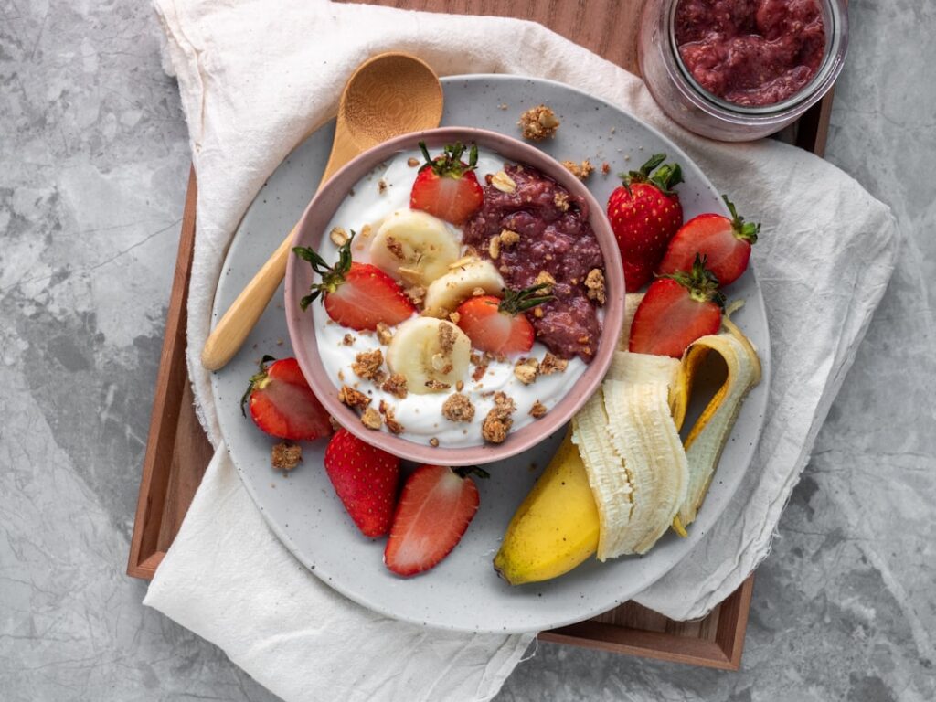 A vibrant aesthetically pleasing yogurt bowl overflowing with fresh fruits like bananas and berries crunchy granola and 