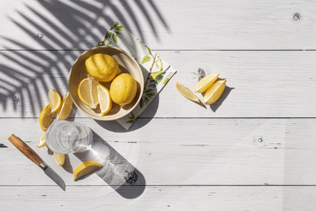 Ingredients for a DIY potato toner a small potato a bottle of rosewater a bottle of aloe vera gel a lemon and a spray bo