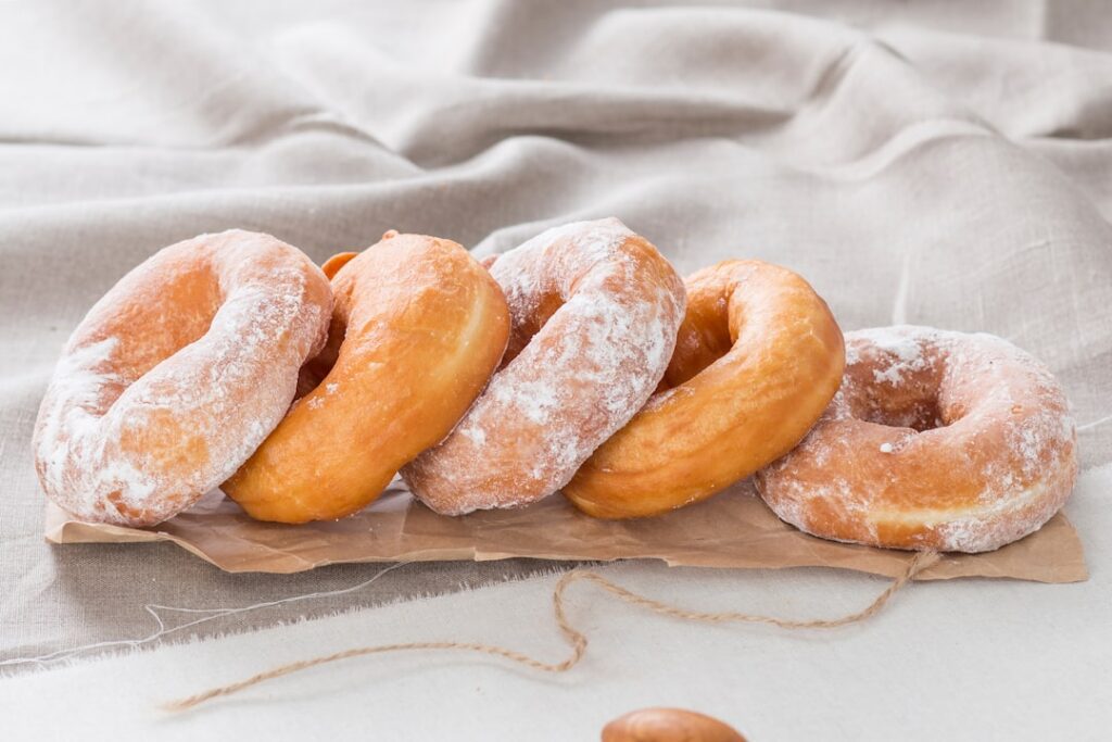 A perfectly glazed homemade donut shiny and smooth on a white plate