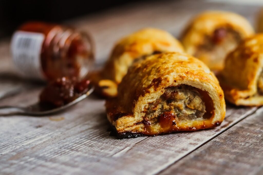Hearty breakfast hand pies filled with sausage and melted cheese baked golden brown on a rustic breakfast table setting