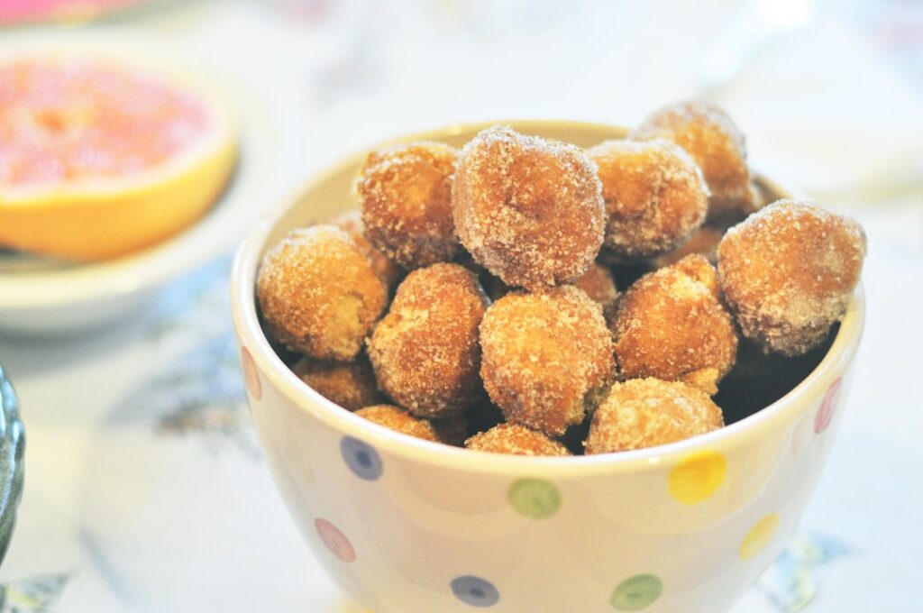 Small round donut balls coated in cinnamon sugar piled artfully