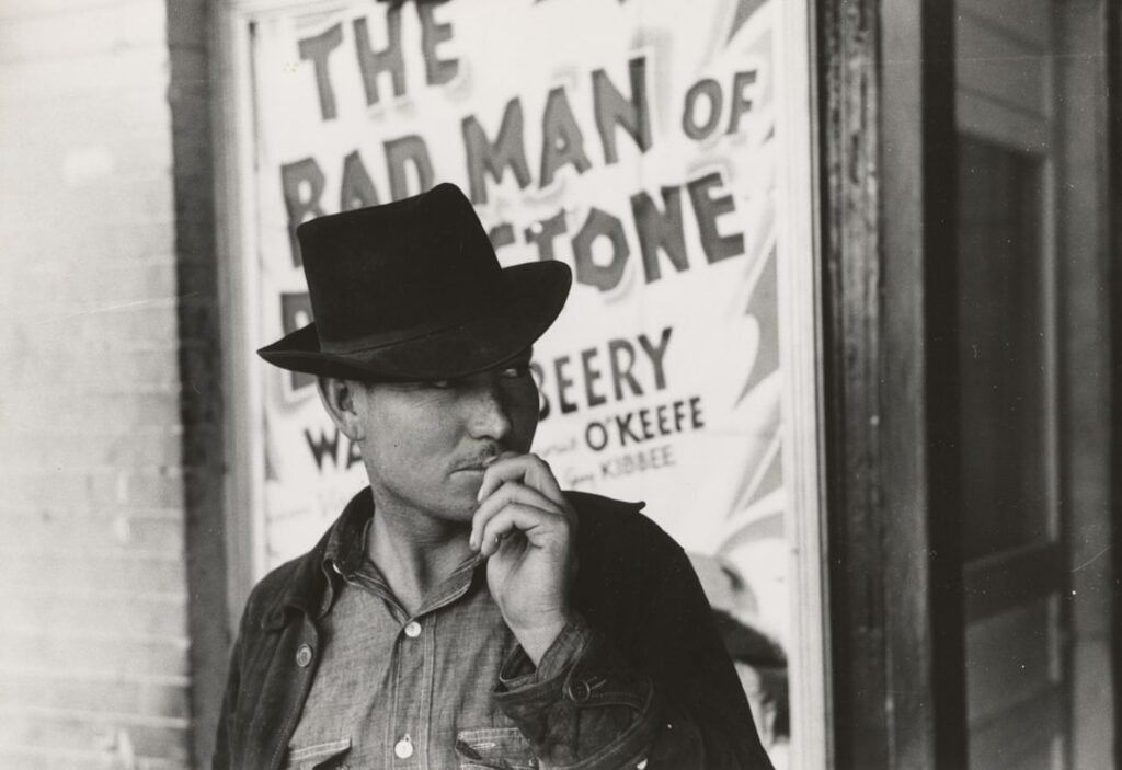 Gary Cooper as Marshal Will Kane in the classic western film High Noon standing alone in a deserted street looking deter
