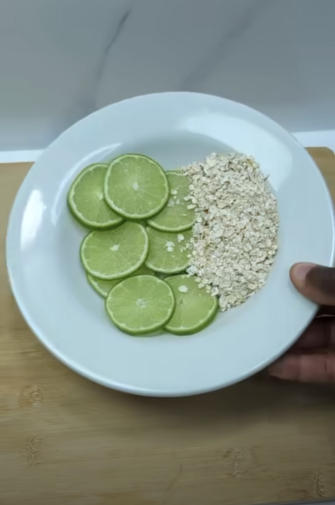 A white plate partially held by a hand resting on a light wooden surface The plate is neatly divided showcasing vibrant 