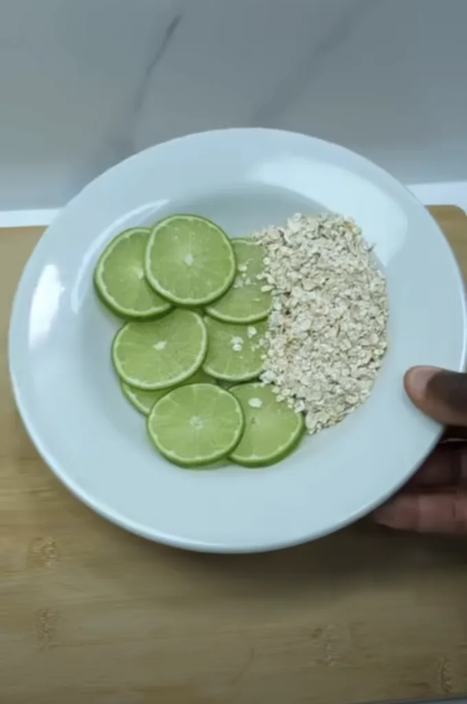 A white plate partially held by a hand resting on a light wooden surface The plate is neatly divided showcasing vibrant 
