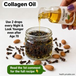 A small glass bottle filled with a light amber oil next to a handful of whole cloves and a small bowl of almond oil on a