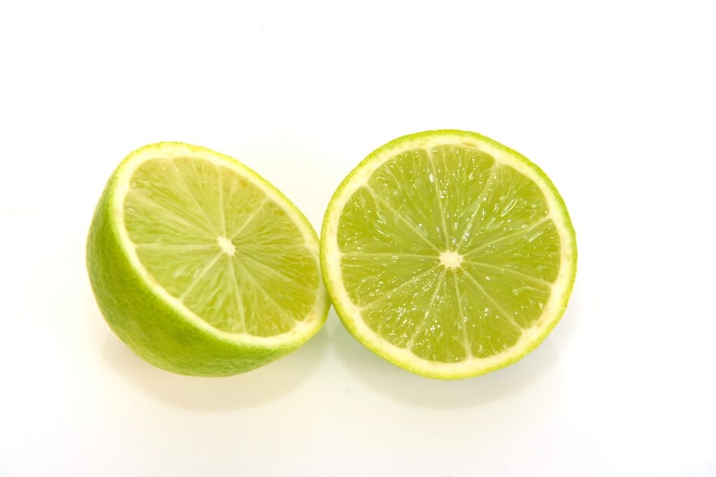 Close-up of fresh coffee grounds and sliced limes on a natural background