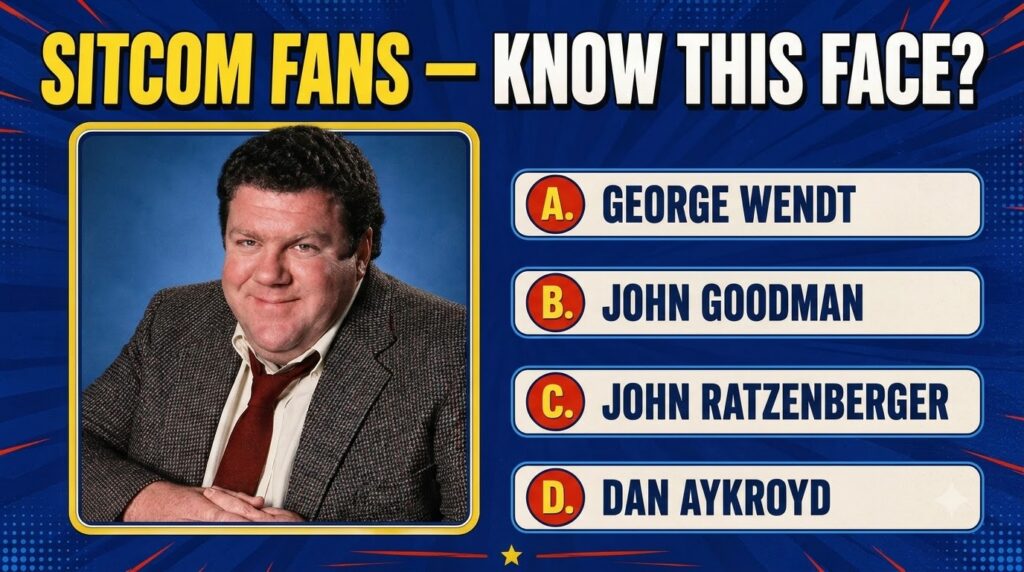 Portrait of actor George Wendt smiling against a plain blue background wearing a tweed jacket white shirt and a red tie 