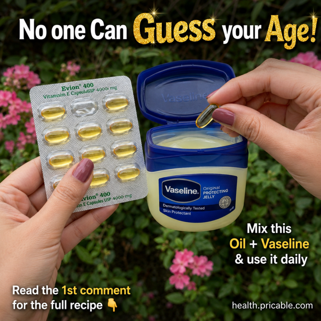 A close-up of hands mixing Vitamin E capsules with Vaseline petroleum jelly in a small jar with lush green foliage in th