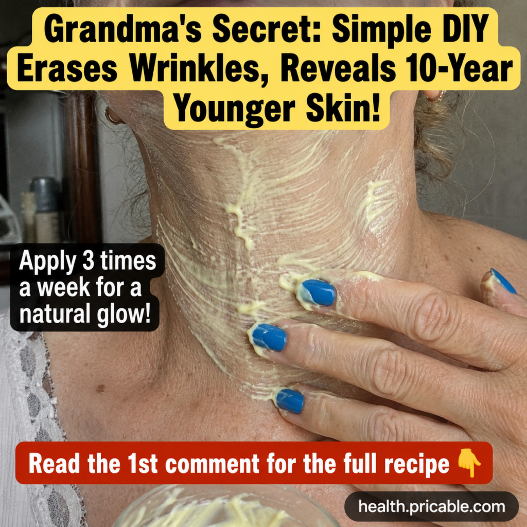A person s hand with blue nail polish applies a thick light yellow creamy mask to their neck which shows some fine lines