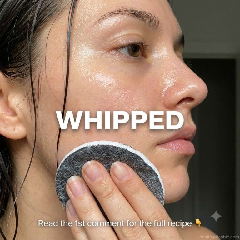 A person with glowing dewy glass skin applies a whipped face wash to their cheek with a soft facial pad with wet hair st