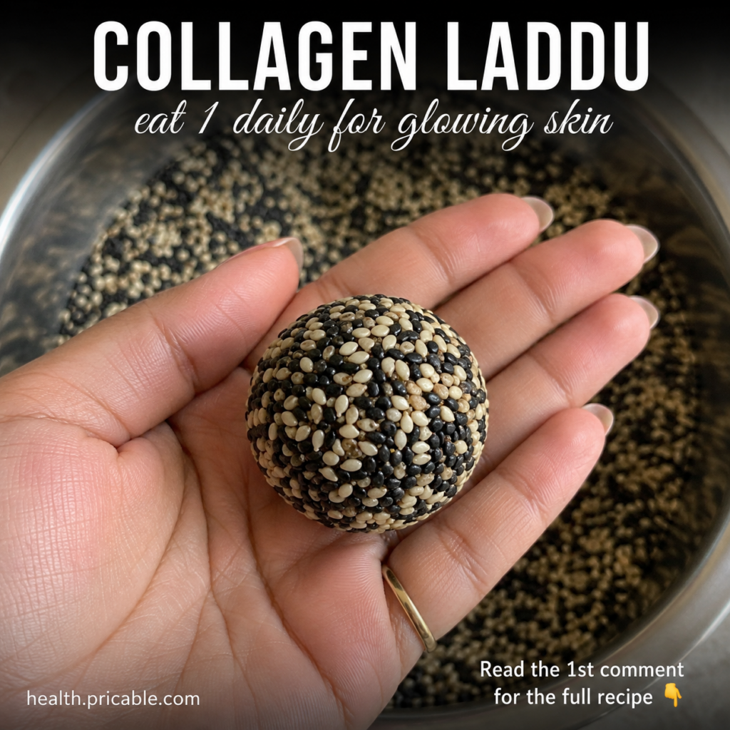 A hand holding a round laddu coated in black and white sesame seeds with more sesame seeds in a blurred background