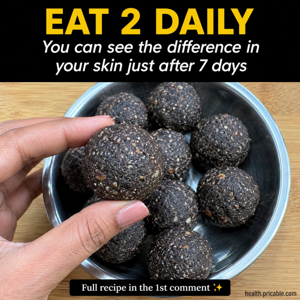 A bowl of golden-brown laddus sweet balls with some nuts and seeds visible presented attractively on a rustic surface