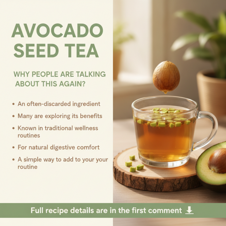A sliced avocado with its pit clearly visible next to a cup of warm amber-colored avocado seed tea perhaps with steam ri