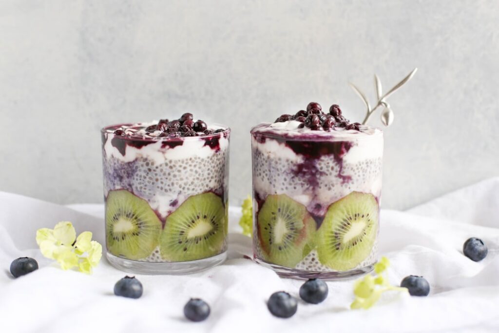 A glass of vibrant berry and chia seed drink with fresh berries and mint