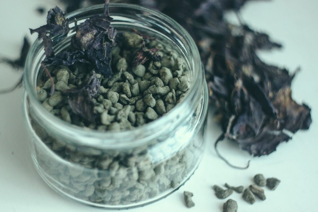 An open glass jar filled with dried chopped Comfrey leaves and roots with a label indicating Comfrey for external use