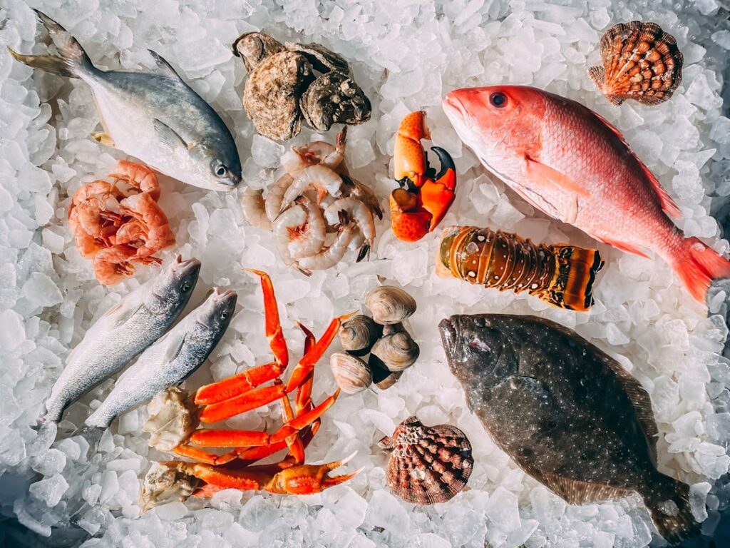 An assortment of various seafood items including different types of fish shellfish like crab prawns mussels and exotic o