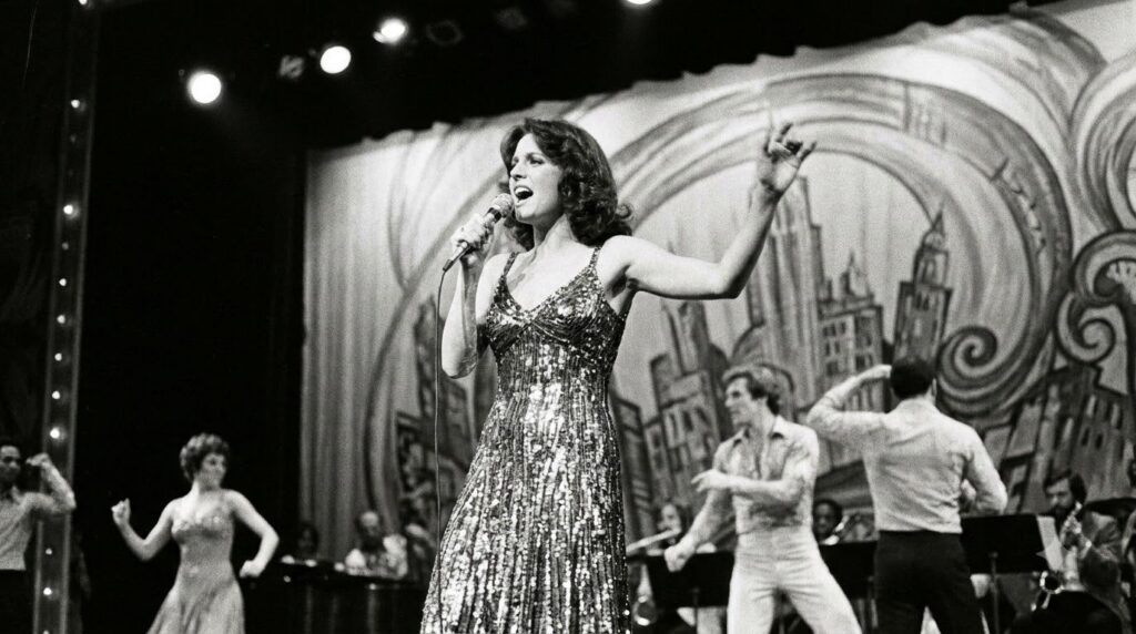 A real archival image of Lucie Arnaz performing on stage in a musical possibly from a Broadway production showing her si