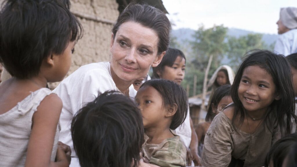 Audrey Hepburn on a humanitarian mission for UNICEF interacting with children in a simple compassionate manner