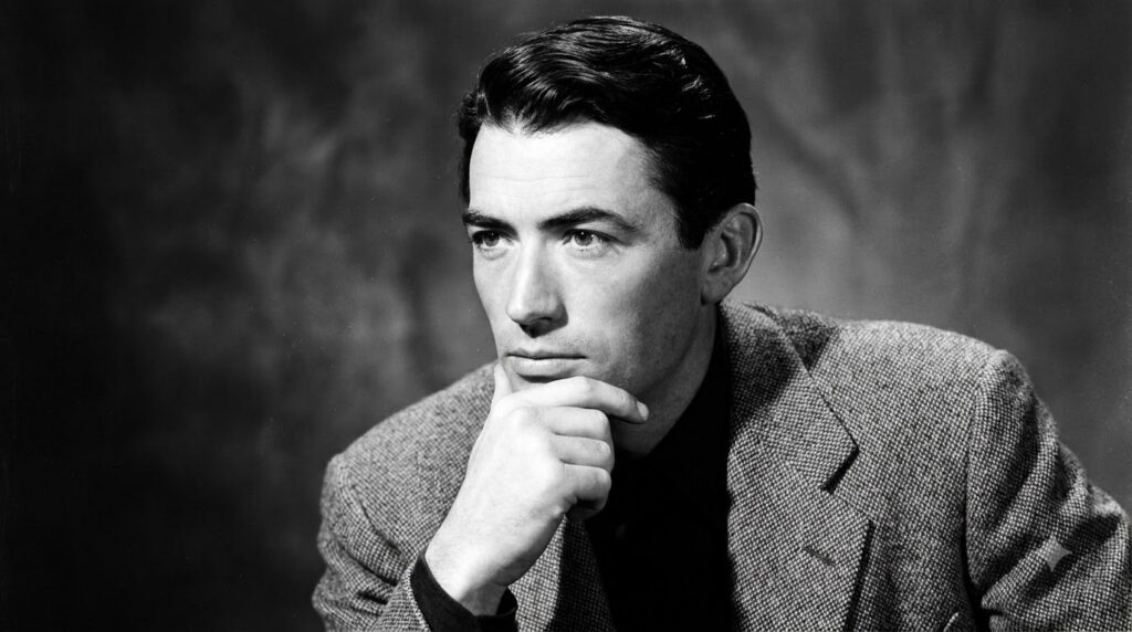 A black and white photograph of Gregory Peck in his prime looking thoughtful and dignified possibly from one of his clas