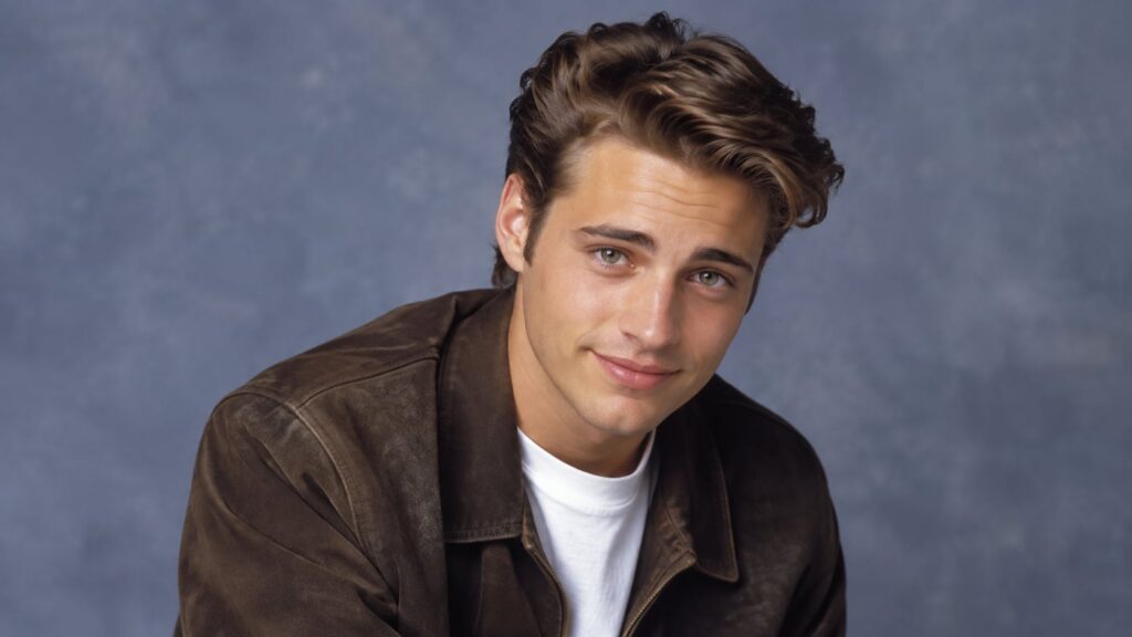 A young Jason Priestley in the 1990s smiling with his signature youthful charm perhaps a headshot or a scene from Beverl