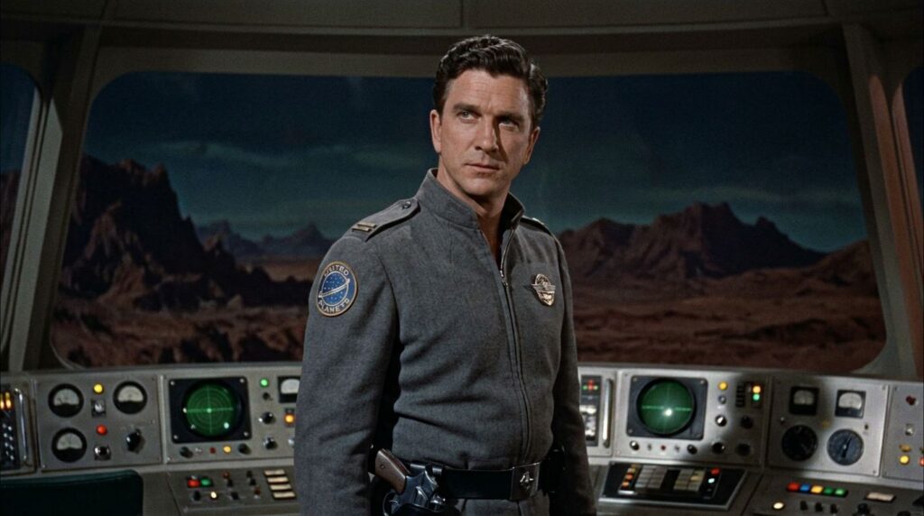 A young Leslie Nielsen in his Commander J J Adams uniform from Forbidden Planet looking serious and authoritative in a s