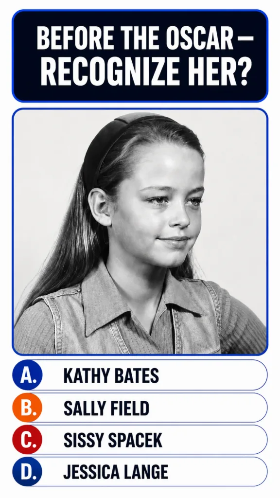 A black and white portrait of a young girl wearing a denim shirt and a headband with long hair looking calmly off-camera