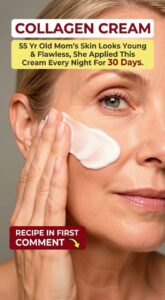A woman in her 50s with a radiant youthful complexion applying a small amount of cream to her face with a gentle smile