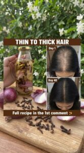 Ingredients for onion and clove hair oil including a chopped red onion whole cloves and a bottle of carrier oil on a woo