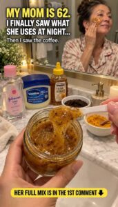 A woman in her 60s with radiant smooth skin applying a coffee scrub to her face with a gentle smile Her skin looks healt