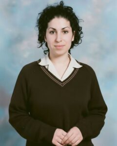 A younger Amy Winehouse before her signature beehive perhaps with simpler makeup looking natural and thoughtful