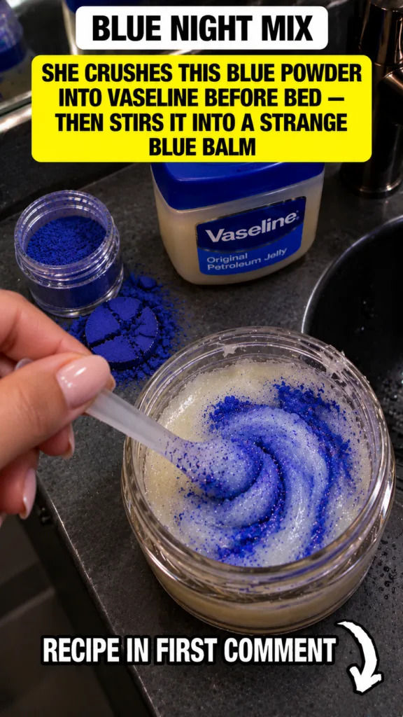 A hand stirring vibrant blue azulene powder into a light-colored Vaseline balm in a glass jar with loose blue powder and