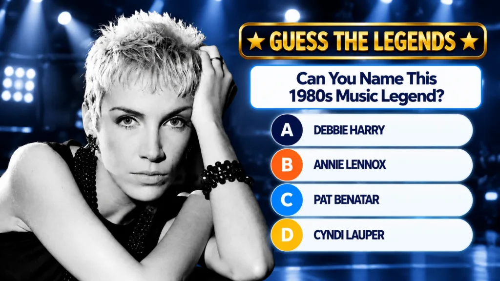 A striking black and white portrait of Annie Lennox with short spiky blonde hair and an intense gaze wearing a dark top 