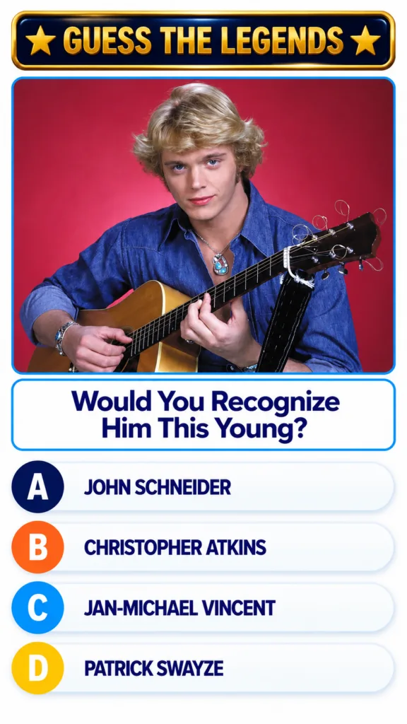 A young John Schneider with blonde hair blue eyes wearing a denim shirt and holding an acoustic guitar set against a red